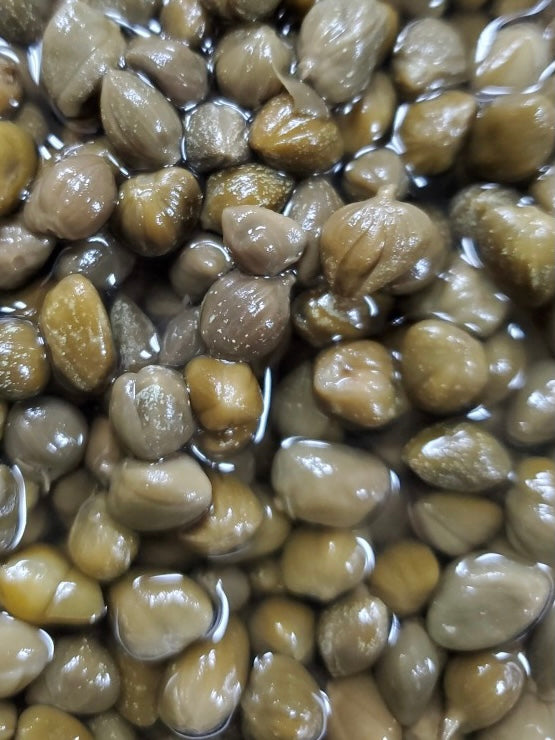 Close up of gray capers non pareilles in vinegar brine